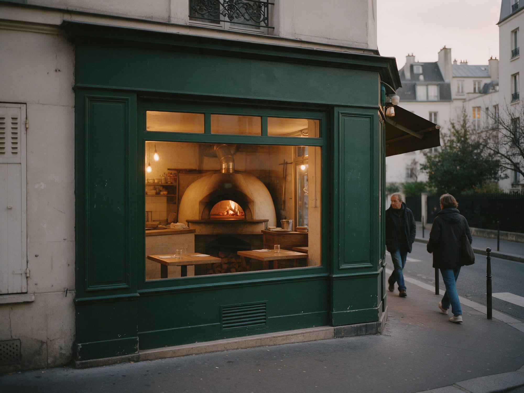 La devanture vert sombre de Forno Vivo, le four allumé derrière la vitrine