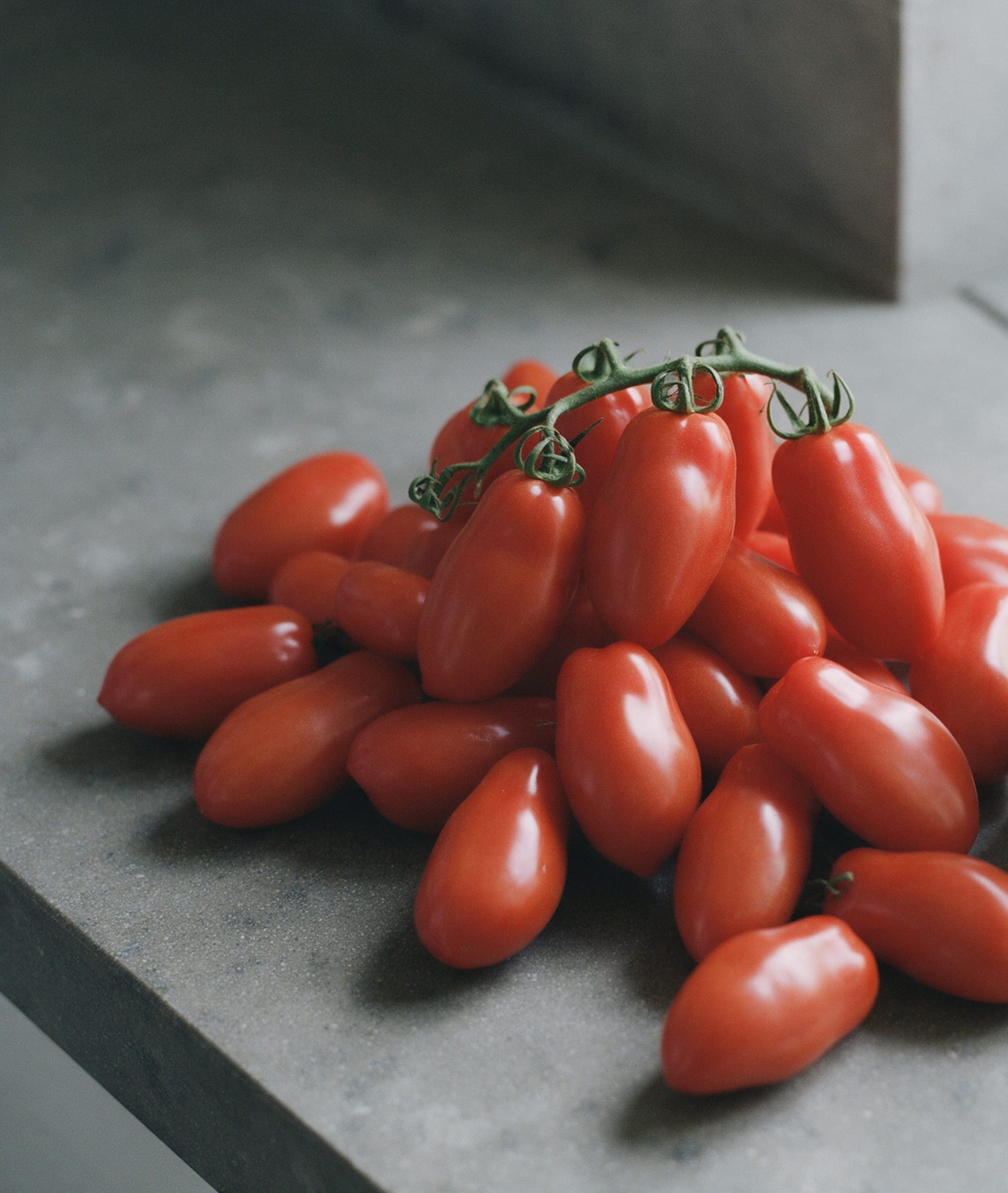 Tomates San Marzano entières sur un plan de travail en pierre